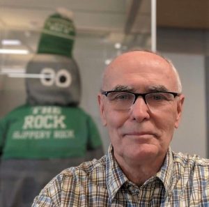 Headshot of Kevin McLatchy with Rocky the Rock mascot in background.
