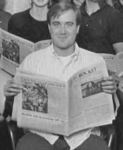 Gorden Ovenshine seated holding an issue of The Rocket newspaper.