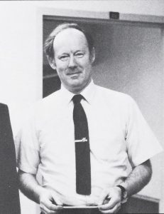Ken Harris standing holding a pencil.